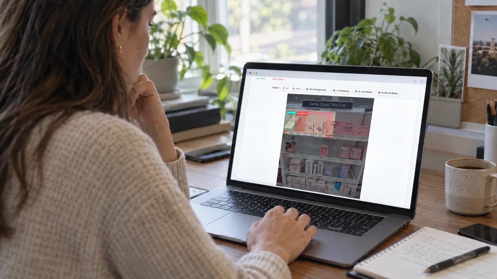 Brand manager reviewing a PlanoIQ retail shelf audit report on a laptop, with low-stock and out-of-stock issues highlighted.